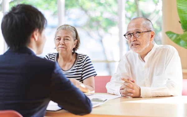 An older couple sits across a table from a younger man.