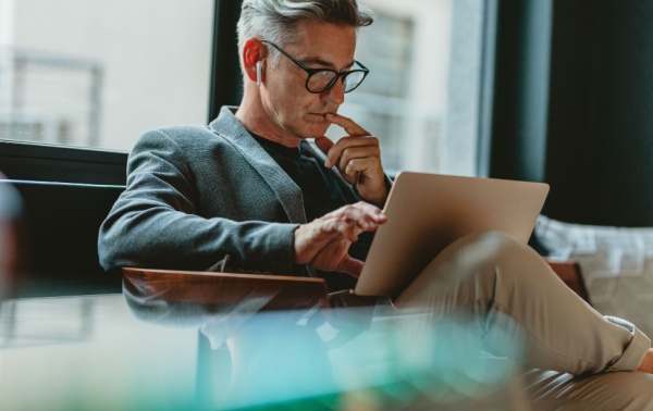 A man reading on a laptop.